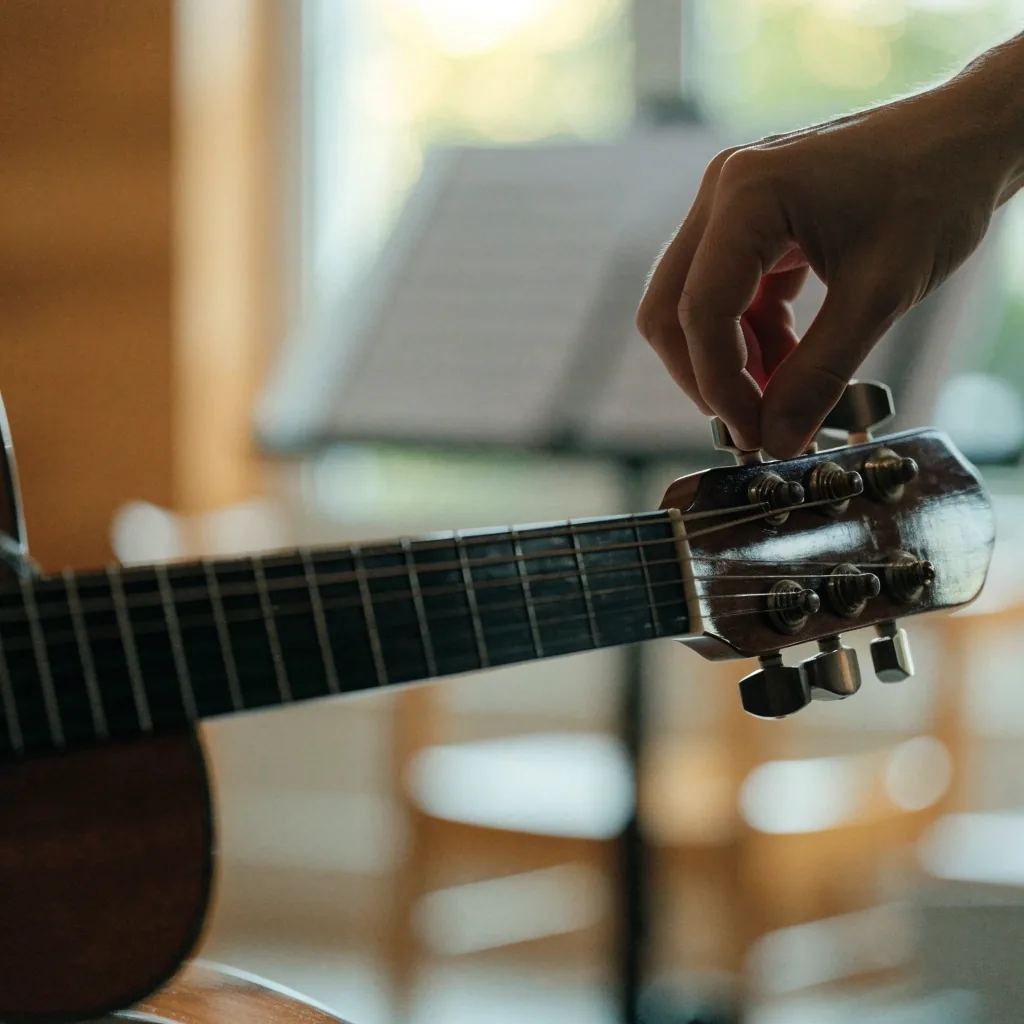 Beginner's hand holding a chord on a guitar fretboard