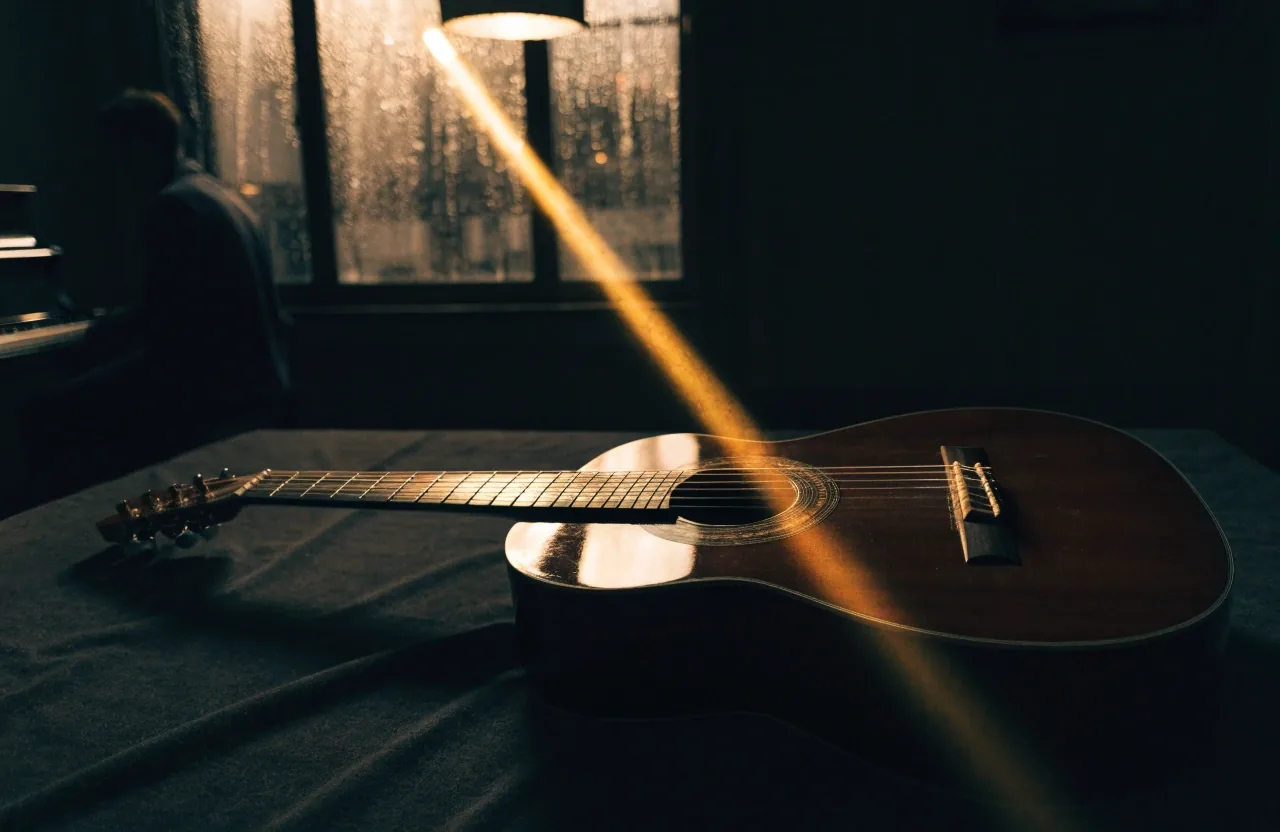 Classical guitar laid flat on dark cloth under low raking light