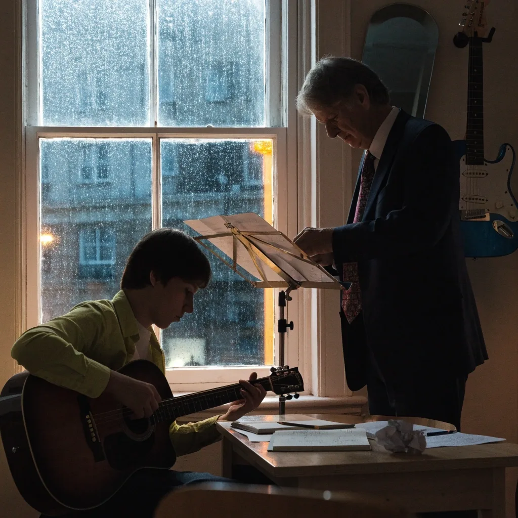 Rain-dimmed northern skyline at dusk seen through a wet window, with city glow and lamp spill at the frame edge